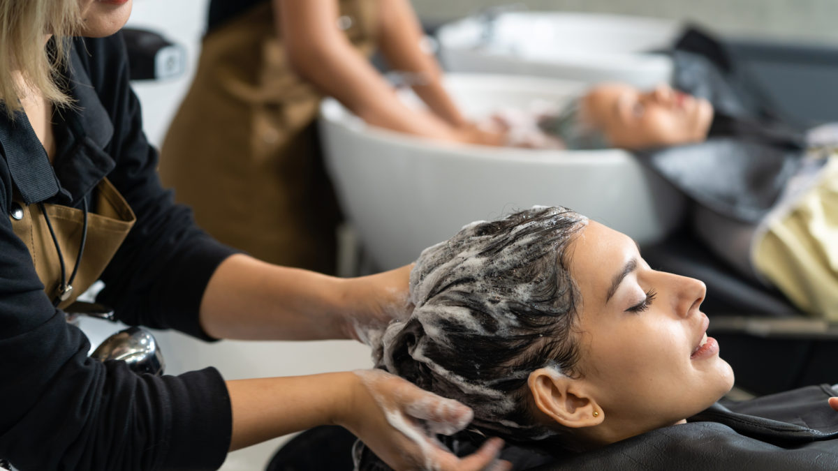 Caucasian female customer getting hair wash service in beauty sa