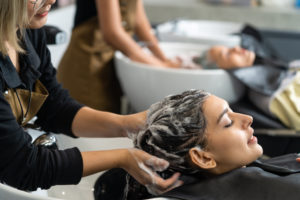 Caucasian female customer getting hair wash service in beauty sa