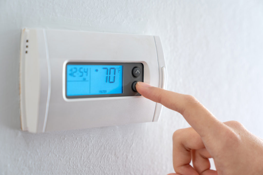 Hand press indoor room thermostat to lower the temp